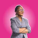 Sandrine Toua debout souriante bras croisé sur fond rose